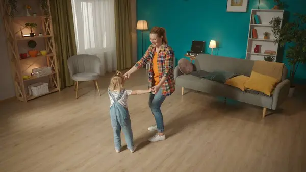 小女孩和可爱的妈妈牵着手在客厅里跳舞 一家人在一起玩得很开心 享受着积极的情绪 家庭关系概念 — 图库照片