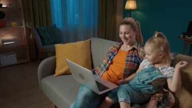 Mutlu, genç bir anne ve genç bir kız kanepede oturup videolar, dizüstü bilgisayarda çizgi filmler izliyorlar. Bir anne akşamleyin oturma odasında kızına beşlik çakıyor. Yavaş