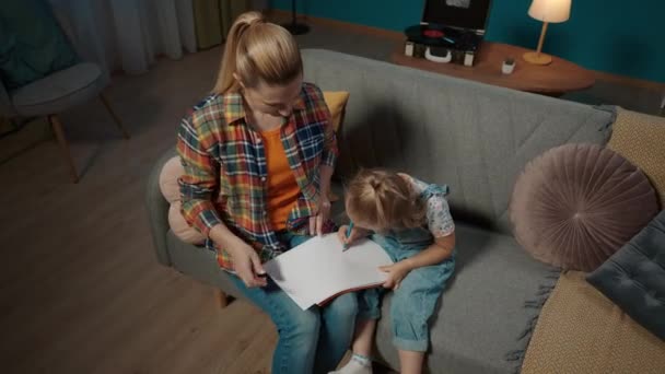 Šťastná Máma Pomáhá Její Dcera Kreslit Barevnými Tužkami Zatímco Sedí — Stock video