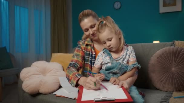 Ευτυχισμένη Μαμά Βοηθά Την Κόρη Της Ζωγραφίσει Χρωματιστά Μολύβια Ενώ — Αρχείο Βίντεο