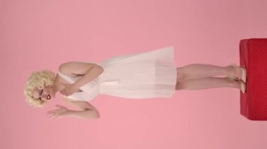 Saldırgan kadın bağırıyor, küfrediyor, birini suçluyor, onu işaret ediyor. Marilyn Monroe 'ya benzeyen kadın nefes veriyor, kendini toparlıyor, saçını düzeltiyor ve gülümsüyor. Ayakta duran kadın