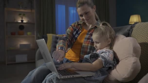 그녀의 컴퓨터 프로그램을 방법을 가르치는 엄마의 거실에서 소파에 온라인 게임을 — 비디오