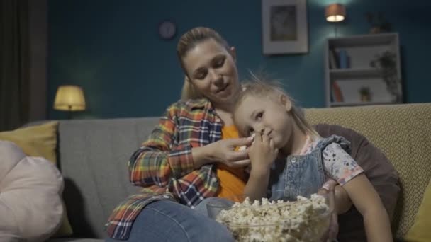 Kochająca Mama Siedząca Kanapie Salonie Przytulona Młodej Córki Oglądającej Telewizję — Wideo stockowe
