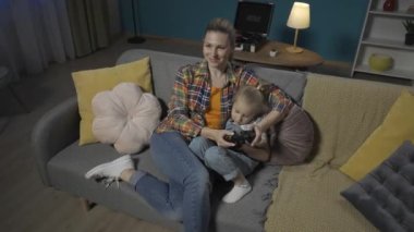 Anne ve küçük kızı joysticklerle oyun oynuyorlar. Anne ve kızı geceyi birlikte geçirir. Oturma odasında televizyon karşısında birbirlerine sarılarak eğlenirler. Aile