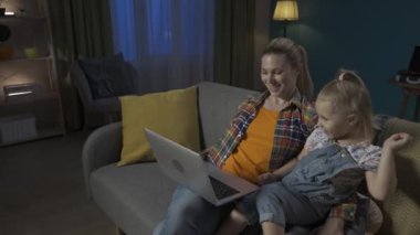 Mutlu, genç bir anne ve genç bir kız kanepede oturup videolar, dizüstü bilgisayarda çizgi filmler izliyorlar. Bir anne akşamleyin oturma odasında kızına beşlik çakıyor. Yavaş