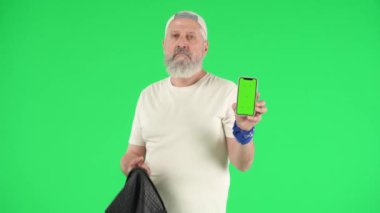Yaratıcı yaşlılar ve modern yaşam tarzı konsepti. Deri ceketli yaşlı rockçı adam portresi ve Krom anahtar yeşil ekran, kameraya havalı görünüyor. Reklam alanı, çalışma alanı modeli.