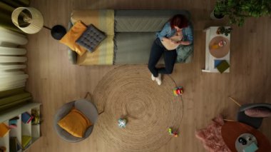 Yukarıdaki karede, hamile bir kadın bir odada kanepede oturuyor. Telefonunu tutuyor, bir şeyler yazıyor, gülümsüyor. Sonra telefonu kaldırdı, bir bardak meyve suyu aldı ve içti..