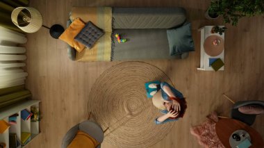 Yukarıdaki karede, odadaki hamile bir kadın bir tartıda duruyor ve beklenti içinde aşağıya bakıyor. Ne kadar kazandığını merak ediyor, mutlu değil, başını alıyor. Yakınlarda bir çocuk oyuncağı yatıyor.