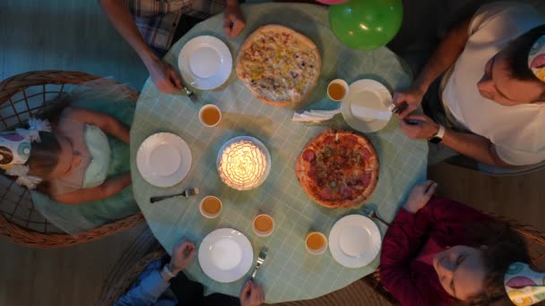 家庭和养育子女的创意概念 客厅里的场景 带派对食品和蛋糕的桌子的顶部视图 家人和朋友庆祝小女孩的生日 快乐的女儿吹蜡烛 — 图库视频影像