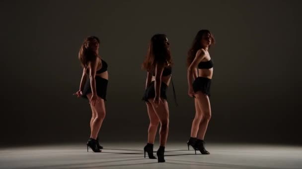 スタジオで踊る女性のグループ スポットライト ブラックセクシーな衣装 ハイヒール 現代のセンセーショナルな振付 全長について プロモーションクリップや広告 — ストック動画