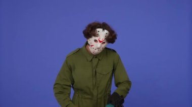 Mavi arka planda elinde testere olan beyaz maskeli bir adam. 13. Cuma 'dan manyak Jason Voorhees' in resmi. Cadılar Bayramı konsepti