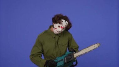 Mavi arka planda elinde testere olan beyaz maskeli bir adam. 13. Cuma 'dan manyak Jason Voorhees' in resmi. Cadılar Bayramı konsepti