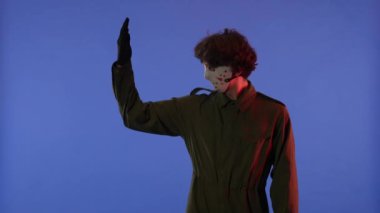 Beyaz maskeli adam elini doğrultuyor ve mavi arka planda kırmızı ışıklı jest yapıyor. 13. Cuma 'dan manyak Jason Voorhees' in resmi. Çalışma alanı, reklam.