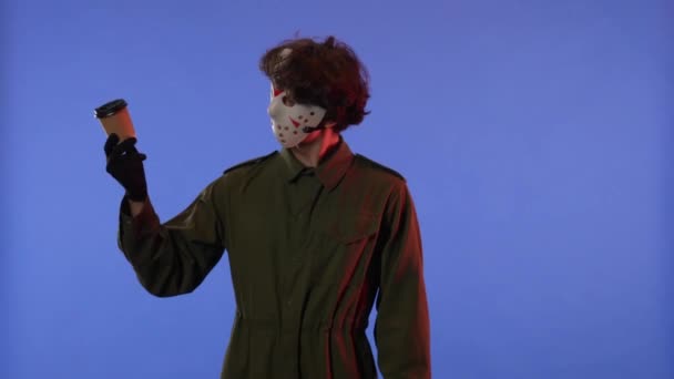 마스크를 남자는 빨간색 빛으로 파란색 배경에 손가락을 보여줍니다 금요일 일에서 — 비디오