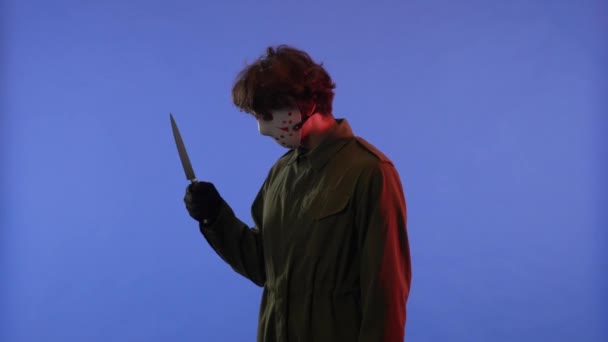 Mann Weißer Maske Mit Großem Scharfen Messer Auf Blauem Hintergrund — Stockvideo