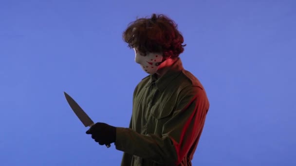 Mann Weißer Maske Mit Großem Scharfen Messer Auf Blauem Hintergrund — Stockvideo