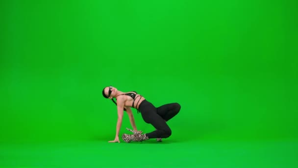现代编舞和舞蹈风格的创意理念 在工作室里 一个迷人的女人穿着高跟鞋在地板上跳着性感的舞步 背景是深绿色的 广告领域模拟 — 图库视频影像