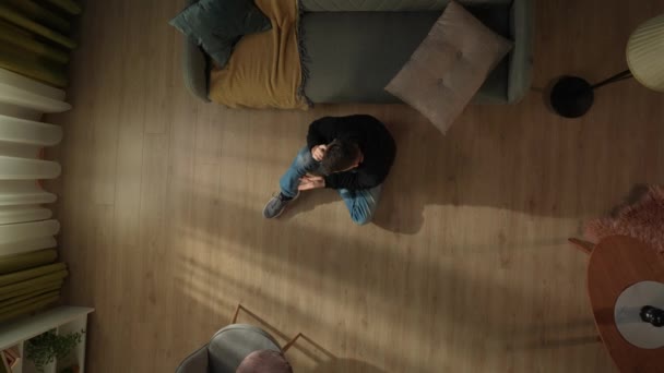 Pandangan Atas Seorang Pria Duduk Lantai Ruang Tamu Dekat Sofa — Stok Video