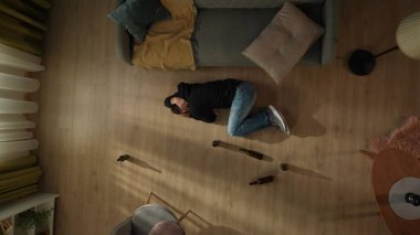 Yerde boş bira şişelerinin yanında yatan bir adamın üst görüntüsü. Kafasını tutan sarhoş bir adam, alkol yüzünden baş ağrısı çekiyor. Alkolizm. Umutsuzluk. Alkol bağımlılığı tedavisi