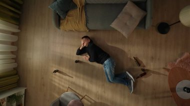 Yerde boş bira şişelerinin yanında yatan bir adamın üst görüntüsü. Kafasını tutan sarhoş bir adam, alkol yüzünden baş ağrısı çekiyor. Alkolizm. Umutsuzluk. Alkol bağımlılığı tedavisi