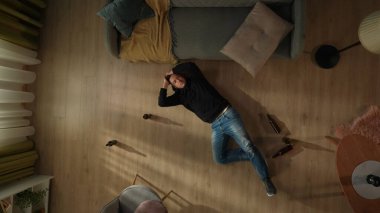 Bira şişelerinin arasında yatan sarhoş bir adamın en iyi görüntüsü. Adam başını tutuyor, baş ağrısı çekiyor. Alkolizm. Umutsuzluk. Alkol bağımlılığı tedavisi