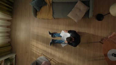 Oturma odasında oturmuş faturalara bakan bir adamın en iyi görüntüsü. Adam kamu borcu için endişeleniyor.