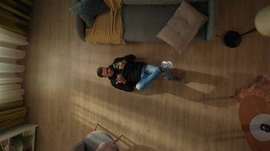 Elinde akıllı bir telefonla oturma odasında yerde yatan şok olmuş bir adamın en üst görüntüsü. Gadget bağımlılığı