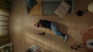 Alkolizm kavramı. Sigara içen bir adamın, oturma odasında yerde, kül tablası ve viski şişesinin yanında yatışının en üst görüntüsü.