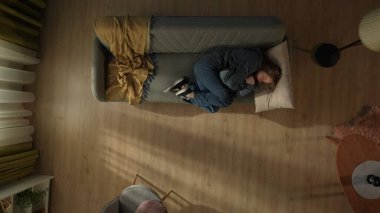 Oturma odasındaki kanepede uzanmış yastığa sarılan bir kadının en iyi görüntüsü. Depresyondaki kadın acı çekiyor, ağlıyor. Yalnızlık, mutsuzluk, depresyon, umutsuzluk kavramı