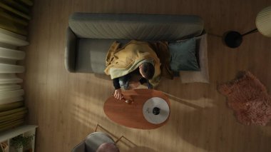 Oturma odasında tek başına içki içen bir adamın en iyi görüntüsü. Ekoseyle kaplı bir adam sehpanın önündeki koltukta otururken bardağa alkol döker. Alkolizm. Alkol bağımlılığı