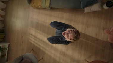 Mutsuz bir kadının oturma odasının en üst görüntüsü. Kadın başını tutuyor ve bağırıyor. Depresyon, stres