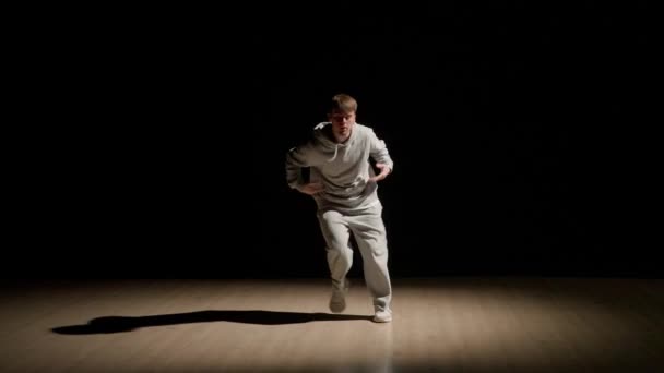 Záběru Mladý Muž Tančí Tmavém Pozadí Nad Ním Svítí Reflektor — Stock video