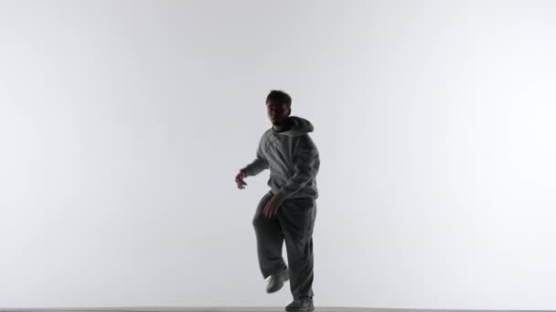 Рамке Белом Фоне Встречным Светом Танцует Молодой Человек Одетый Уличный — стоковое видео