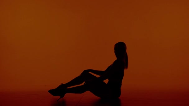 Frame Woman Sits Silhouette Red Background Wearing High Heels Demonstrates — Stock Video