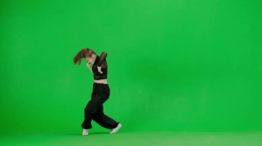 Modern koreografi ve dans stili yaratıcı konsept. Kadın dansçı portresi. Siyah kıyafetli çekici bir kız modern koreografiyi krom anahtar yeşil ekran arka planında dans ediyor..