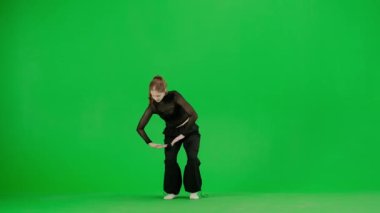 Modern koreografi ve dans stili yaratıcı konsept. Kadın dansçı portresi. Siyah kıyafetli çekici bir kız Chroma Key Green Screen arka planında dans ediyor..