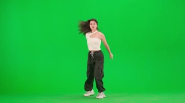 Modern koreografi ve dans stili yaratıcı konsept. Beyaz bluzlu, enerjik caz funk dans eden çekici kadın stüdyoda krom anahtar yeşil ekran arka planda hareket ediyor. Reklam alanı modeli.