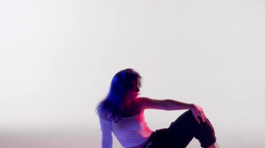 Modern koreografi ve dans stili yaratıcı konsept. Kadın dansçı portresi. Kırmızı-mavi ışıklı, dans eden caz funk dans eden, stüdyoda beyaz arka planda izole bir kadın..