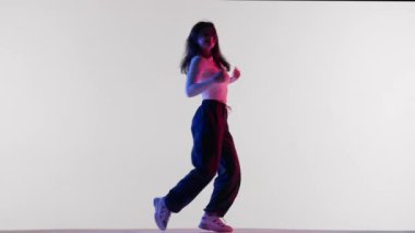 Modern koreografi ve dans stili yaratıcı konsept. Kadın dansçı portresi. Kırmızı ve mavi neon ışıklı çekici kadın jazz funk dansı elementleri, bir stüdyoda beyaz arka planda izole..