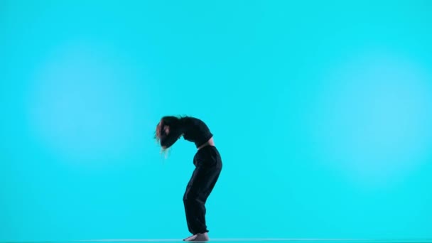 现代编舞和舞蹈风格的创意理念 女舞蹈家的画像 演播室里穿着深蓝色背景的当代现代舞中的黑色服装舞蹈元素的迷人的女孩形象 — 图库视频影像