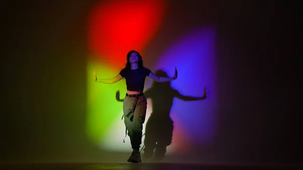 现代舞编舞创意广告的概念 穿着上衣和卡其裤的迷人女人在摄影棚里跳爵士舞 与红色绿色霓虹灯背景隔离 — 图库照片