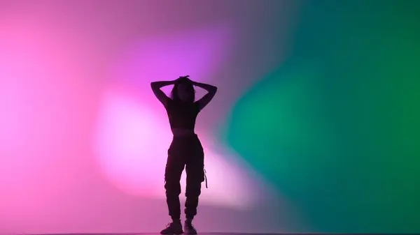 现代舞编舞创意广告的概念 穿着上装和黑色裤子的迷人女人在摄影棚里跳爵士舞 与粉色绿色霓虹灯背景隔离 — 图库照片
