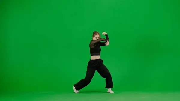 现代创意舞蹈和舞蹈概念 女舞蹈家的画像 穿着黑色服装的年轻貌美的姑娘在色彩缤纷的绿色背景上跳着当代的舞曲 — 图库照片