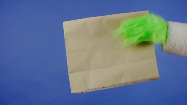 Гречки Зеленоволосиста Рука Тримає Паперовий Мішок Ізольованому Синьому Фоні Подарунковий — стокове відео