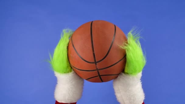 Grinchs Green Hairy Hands Holding Out Basketball Blue Isolated Background — Stock Video