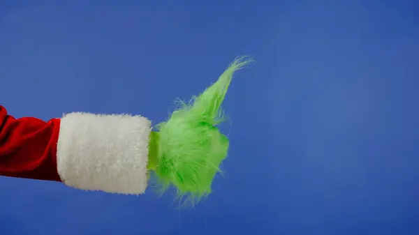 Grønnhåret Grinch Hånd Viser Tommel Opp Bevegelse Isolert Blå Bakgrunn – stockfoto