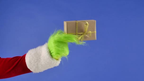 Grinchs Πράσινο Μαλλιά Χέρι Κρατά Ένα Λευκό Κουτί Δώρου Ένα — Αρχείο Βίντεο