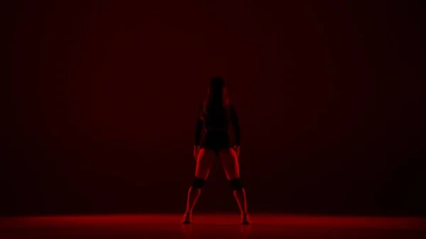 Karanlık Bir Arkaplanda Üzerinde Genç Bir Kadın Duruyor Kırmızı Bir — Stok fotoğraf