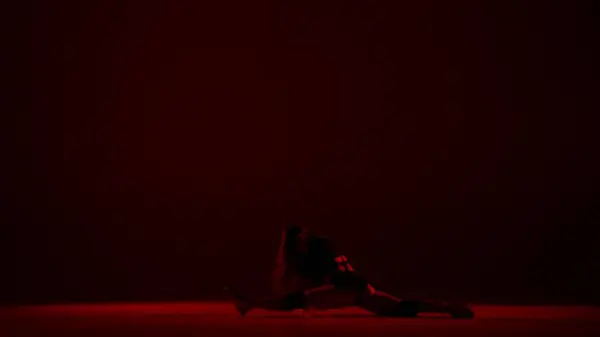 Het Kader Een Donkere Achtergrond Knielende Vrouw Een Rood Licht — Stockfoto