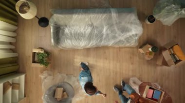 Yeni ev ve gayrimenkul yaratıcı reklam konsepti. Taşınma ve tahliye. Üst kattaki oturma odası. Adam akıllı telefondan video kaydediyordu. Bir kadının yeni bir dairede oda turunu göstermesi ve yapması....